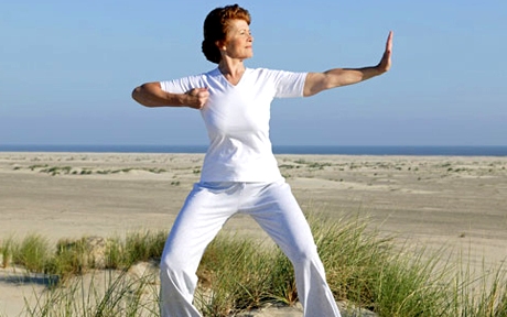 photolibrary rm photo of woman doing tai chi on beach